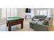 Bright living space with pool table, plush seating, and bay windows with plantation shutters at 723 Seclusion Glen Ave, Las Vegas, NV 89123