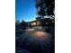 Inviting home exterior with a stone pathway, illuminated landscaping, and a stately facade, perfect for evening enjoyment at 7451 Mystic Stream St, Las Vegas, NV 89131