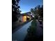 Charming home exterior featuring a covered entryway, lush landscaping, and a serene, inviting ambiance at twilight at 7451 Mystic Stream St, Las Vegas, NV 89131
