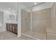 Modern bathroom with a glass-enclosed shower, double sinks, and stylish tile flooring, offering a luxurious feel at 7482 Lodano Ave, Las Vegas, NV 89113