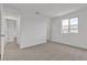 An empty carpeted bedroom boasts neutral paint, multiple doors, and a bright window at 7482 Lodano Ave, Las Vegas, NV 89113