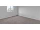 An empty carpeted bedroom with window is ready for your personal touch and decoration at 7482 Lodano Ave, Las Vegas, NV 89113