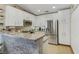 This kitchen includes white cabinets, stone backsplash, granite countertop, and stainless steel refrigerator at 7608 Vista Hills Dr, Las Vegas, NV 89128
