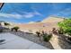 Private backyard with stone landscaping and colorful flowers on a bright day at 7732 Songster St, North Las Vegas, NV 89084