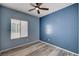 This is a cozy bedroom with natural light, wood-look flooring and a ceiling fan at 7732 Songster St, North Las Vegas, NV 89084