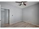 This bedroom has neutral walls, wood-look flooring, ceiling fan, and an open doorway at 7732 Songster St, North Las Vegas, NV 89084
