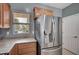 Kitchen view of stainless steel refrigerator and adjacent window at 7732 Songster St, North Las Vegas, NV 89084