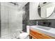Stylish bathroom boasts a modern sink, dark tile shower, and sleek, round mirror at 7900 Riviera Beach Dr, Las Vegas, NV 89128