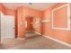Bedroom with orange walls with white trim featuring mirrored closet doors and neutral carpet at 7900 Riviera Beach Dr, Las Vegas, NV 89128