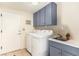 A laundry room featuring a washer, dryer, sink, cabinets and a white door at 7900 Riviera Beach Dr, Las Vegas, NV 89128