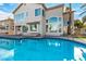 A beautiful backyard pool and patio with spacious two-story home featuring large windows overlooking the pool at 7900 Riviera Beach Dr, Las Vegas, NV 89128