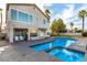 A tranquil backyard oasis with a sparkling pool, palm trees, and comfortable seating, perfect for relaxation and entertainment at 7900 Riviera Beach Dr, Las Vegas, NV 89128