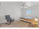 Comfortable bedroom features neutral carpet, ceiling fan, and a cozy seating area at 7954 Kentshire Dr, Las Vegas, NV 89117