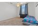 Bright bedroom features neutral carpet, ceiling fan, and a large window at 7954 Kentshire Dr, Las Vegas, NV 89117