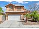 Inviting two-story home featuring a white garage door, complemented by desert landscaping and a tiled roof at 7954 Kentshire Dr, Las Vegas, NV 89117