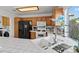Bright kitchen featuring white tile counters, oak cabinets, black appliances and a double sink at 7954 Kentshire Dr, Las Vegas, NV 89117