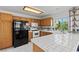 Well-lit kitchen with oak cabinets, tiled countertops, and stainless steel appliances, perfect for cooking at 7954 Kentshire Dr, Las Vegas, NV 89117