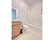 This bright bathroom shows a tiled shower-tub combination and a wooden vanity with modern fixtures at 80 Brixton Ave, Henderson, NV 89011