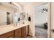 Bathroom with dual sinks, framed mirror, and adjacent bedroom view at 8084 Celina Hills St, Las Vegas, NV 89131