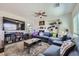 Spacious living room featuring plush blue sectional sofa, large television, fireplace, and an abundance of natural light at 8084 Celina Hills St, Las Vegas, NV 89131
