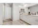 Bright bathroom featuring a granite countertop, double sinks, and white cabinets at 8351 Gold River Ct, Las Vegas, NV 89113