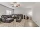 Spacious living room features a plush, leather sectional sofa, modern ceiling fan, and shuttered windows at 8351 Gold River Ct, Las Vegas, NV 89113