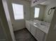 Well-lit bathroom with a dual-sink vanity, light granite countertops, and a large mirror at 9159 Oxford Blue Ave, Las Vegas, NV 89148