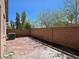 Backyard with a concrete patio, privacy wall, and mature trees at 9463 Jumping Frog Ct, Las Vegas, NV 89147