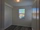 Neutral bedroom with wood-look flooring, a window, and a closet at 9463 Jumping Frog Ct, Las Vegas, NV 89147