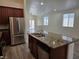 Open concept kitchen featuring granite countertops, stainless appliances, and dark wood cabinets at 9463 Jumping Frog Ct, Las Vegas, NV 89147