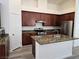 Kitchen island with stainless steel appliances, stone countertops, and dark cabinets at 9463 Jumping Frog Ct, Las Vegas, NV 89147