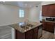 Granite island with stainless dishwasher and sink in open concept kitchen and living area at 9463 Jumping Frog Ct, Las Vegas, NV 89147