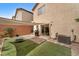 Enclosed backyard featuring a patio, artificial grass and shade for outdoor enjoyment at 9737 Darlington Ct, Las Vegas, NV 89149