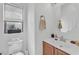 Cozy bathroom with a toilet, a sink with wood cabinets, and a round mirror at 9737 Darlington Ct, Las Vegas, NV 89149