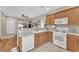 Traditional kitchen featuring oak cabinets, white appliances, and tile flooring at 9737 Darlington Ct, Las Vegas, NV 89149