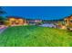 Expansive backyard with lush green lawn, mature trees, and outdoor entertainment spaces at 9920 Rancho Destino Rd, Las Vegas, NV 89183