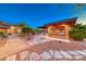 Beautiful backyard featuring stone walkways, manicured landscaping, and an outdoor kitchen area at 9920 Rancho Destino Rd, Las Vegas, NV 89183