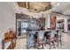 Entertainers bar featuring stone countertops, custom cabinetry and a stainless steel wine fridge at 9920 Rancho Destino Rd, Las Vegas, NV 89183