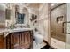 A modern bathroom with a dark wood vanity, marble countertop, and a walk-in shower at 9920 Rancho Destino Rd, Las Vegas, NV 89183