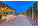 Expansive driveway leading to a luxury home with manicured landscaping and porte cochere at 9920 Rancho Destino Rd, Las Vegas, NV 89183