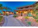Charming front entrance with stone accents, manicured landscaping, and a cozy porch swing at 9920 Rancho Destino Rd, Las Vegas, NV 89183