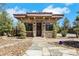 Exterior view of a charming stone guest house with a well-manicured front yard at 9920 Rancho Destino Rd, Las Vegas, NV 89183
