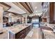 A spacious kitchen featuring an oversized island, marble countertops, stainless steel appliances and ample seating at 9920 Rancho Destino Rd, Las Vegas, NV 89183