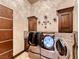 This laundry room features modern washer and dryer units, stylish cabinets, and elegant decor at 9920 Rancho Destino Rd, Las Vegas, NV 89183