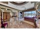 Bright main bedroom features backyard views, designer ceilings, seating area and high-end furniture at 9920 Rancho Destino Rd, Las Vegas, NV 89183