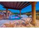 Beautiful pool area featuring a rock waterfall, lush landscaping, and comfortable lounge chairs at 9920 Rancho Destino Rd, Las Vegas, NV 89183