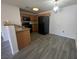 Well-lit kitchen with black appliances, wood cabinetry and wood-look tile flooring at 7701 W Robindale Rd # 127, Las Vegas, NV 89113