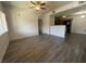 Spacious living room leading to kitchen with wood-look tile flooring and modern ceiling fan at 7701 W Robindale Rd # 127, Las Vegas, NV 89113