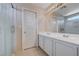Bathroom with dual sinks, large mirror, shower, and tiled floor at 11120 Whooping Crane Ln, Las Vegas, NV 89144