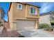 Side view of a two-story home with a two-car garage, and desert landscaping at 11120 Whooping Crane Ln, Las Vegas, NV 89144